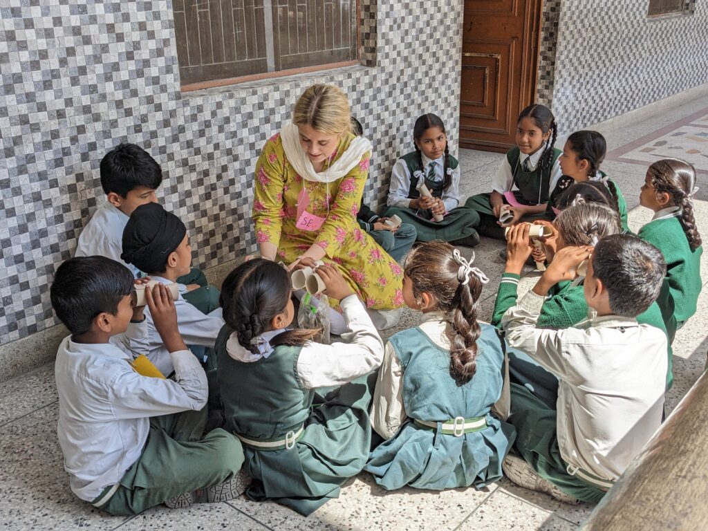 Teaching student working with a group of children in India